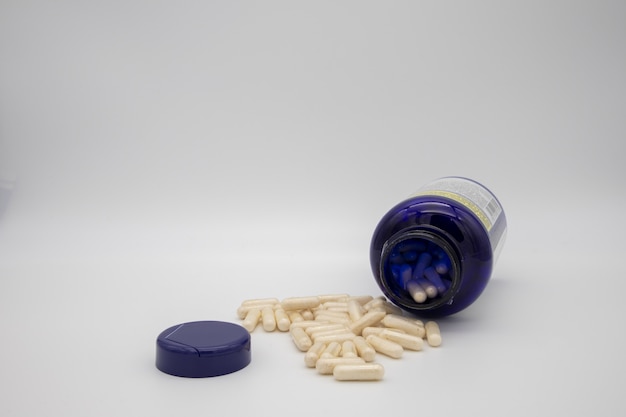 Witte tabletten uit een blauwe pil fles