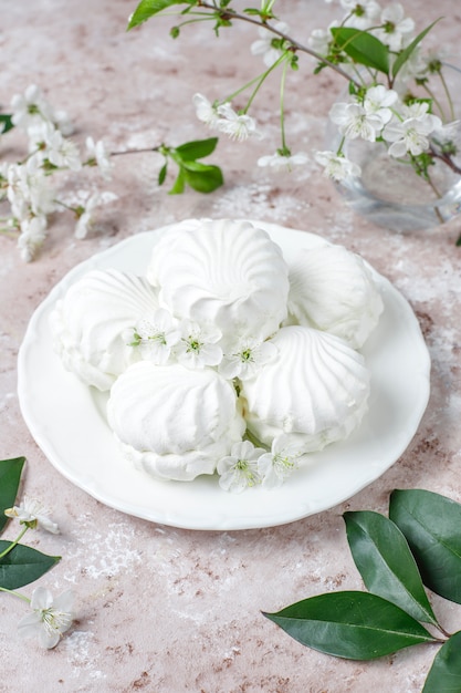 Witte zefier, heerlijke marshmallows met lentebloesem bloemen, bovenaanzicht