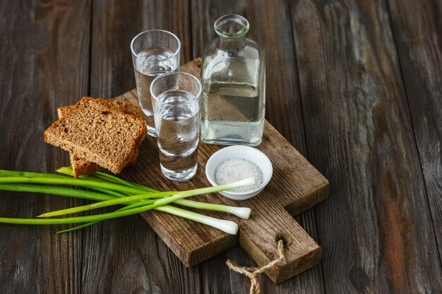 Wodka en traditionele snack op houten muur