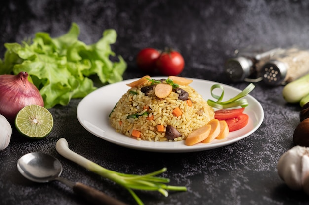 Worst gebakken rijst met tomaten, wortelen en shiitake champignons op het bord