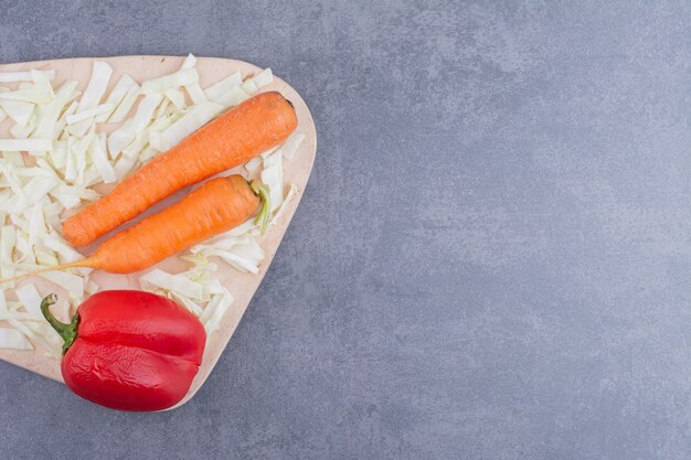 Wortel, rode chilipeper en kool op een houten bord