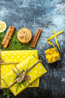 Xmas achtergrond met mooie gele geschenkdozen en gestapelde koekjes citroen kaneel limoenen op donkere achtergrond