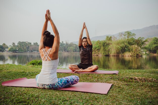 Yoga partners zitten met de handen omhoog