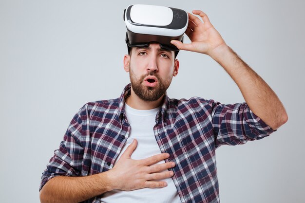 Young bang bebaarde man in shirt met virtual reality-apparaat