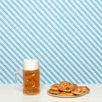 Gratis foto zachte pretzels en blond bier op witte tafel