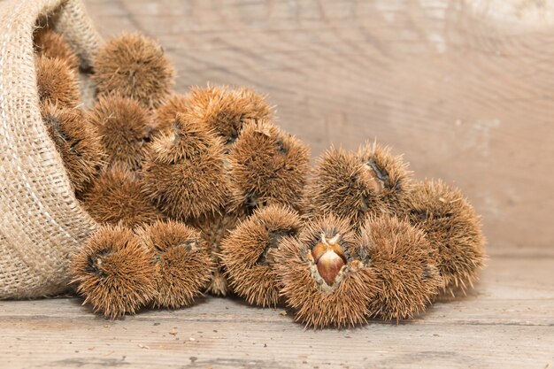 Zak die kastanjes morst op rustiek hout