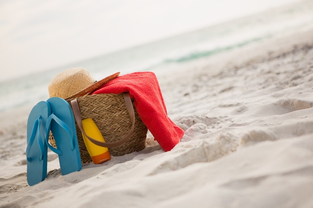 Gratis foto zak met strand accessoires gehouden op zand