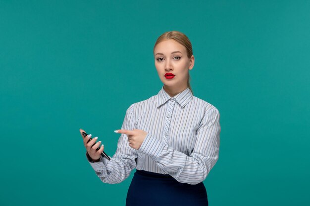 Zakelijke dame mooie blonde vrouw in kantooroutfit wijzend op telefoon