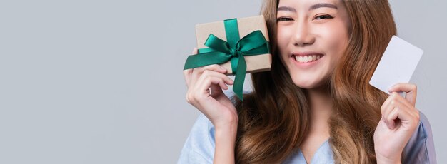 Zakelijke gezonde verzekering mooie aziatische vrouw in ziekenhuis uniforme glimlach met hand show creditcard en cadeau-ideeën voor gelukkig verzekeringspakket en promotie met ziekenhuis wazige achtergrond