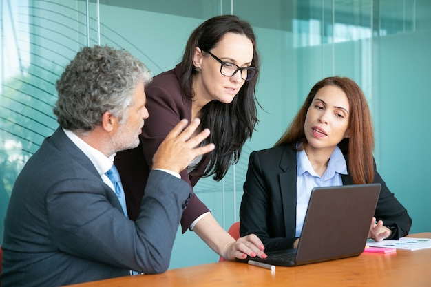 Zakelijke partners kijken naar presentatie en project bespreken tijdens vergadering.