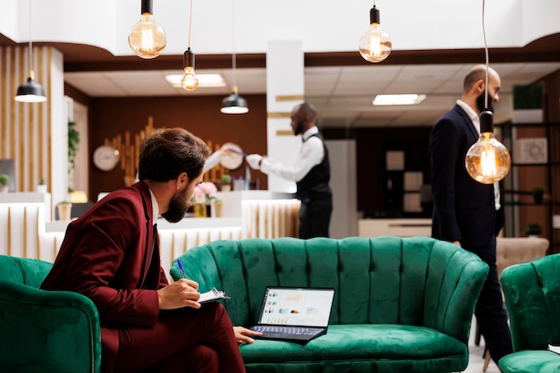 Zakelijke professional die nieuwe ideeën vindt om internationaal partnerschap te smeden voordat hij de conferentie, de hotellounge bijwoont. CEO maakt aantekeningen en bereidt zich voor op een belangrijke toespraak.