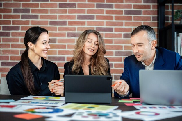 Zakelijke sessie in een kantoor Vrouwen en een man bespreken zakelijke aangelegenheden Gadgets en papieren