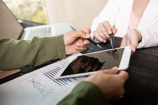 zakelijke teamvergadering om statistische gegevens te bespreken die worden gepresenteerd in de vorm van digitale grafieken en diagrammen.