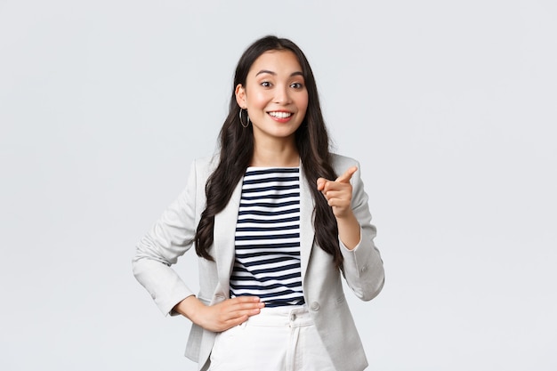 Zaken, financiën en werkgelegenheid, concept van vrouwelijke ondernemers. Glimlachende succesvolle aziatische zakenvrouw die een toespraak houdt over de vergadering, een leuk idee van de werknemer prijst, een wijzende vinger zegt een goed punt.