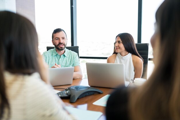 Zakenlieden en zakenvrouwen die aan laptops werken in vergadering op kantoor