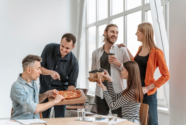 Zakenlieden eten pizza tijdens de lunchpauze.