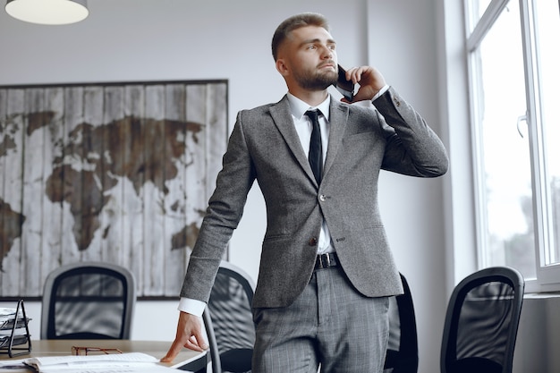 Zakenman aan het werk op kantoor. Man is praten over de telefoon. Guy in een pak