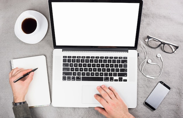 Zakenman die digitale tablet gebruiken die op klembord met pen over het grijze bureau schrijven