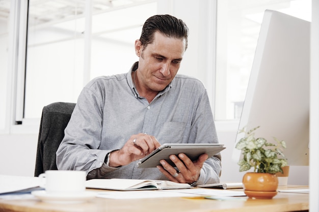 Zakenman die gadgets op het werk gebruikt