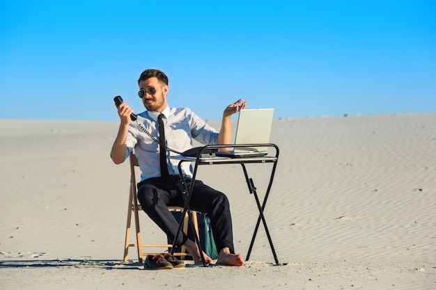 Zakenman die laptop in een woestijn met behulp van
