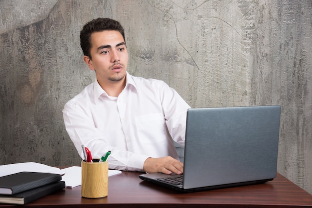 Zakenman die laptop onderzoekt en aan de balie zit. hoge kwaliteit foto