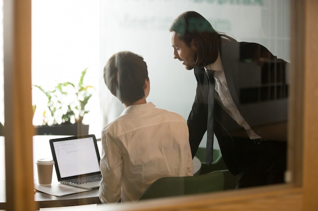 Zakenman die onderneemsterbrainstorming helpen die e-mail op laptop, achtermening bespreken