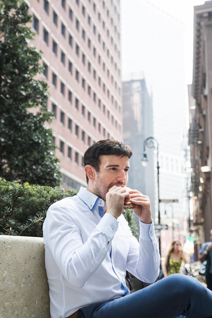 Gratis foto zakenman die op bank eet