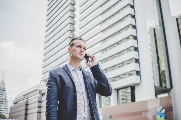 Zakenman die op celtelefoon spreekt dichtbij commercieel centrum