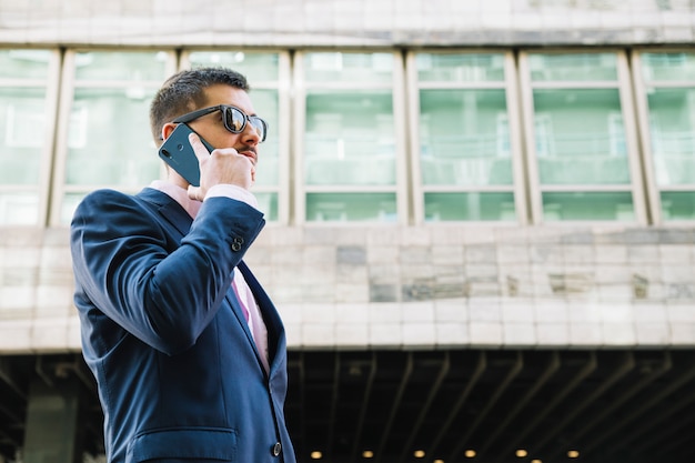 Zakenman die telefoongesprek in stedelijk milieu maakt