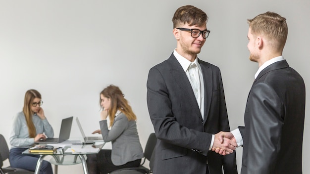 Gratis foto zakenman die zijn partner begroet tijdens vergadering