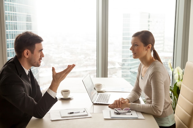 Zakenman en onderneemster die het werk bespreken bij bureau