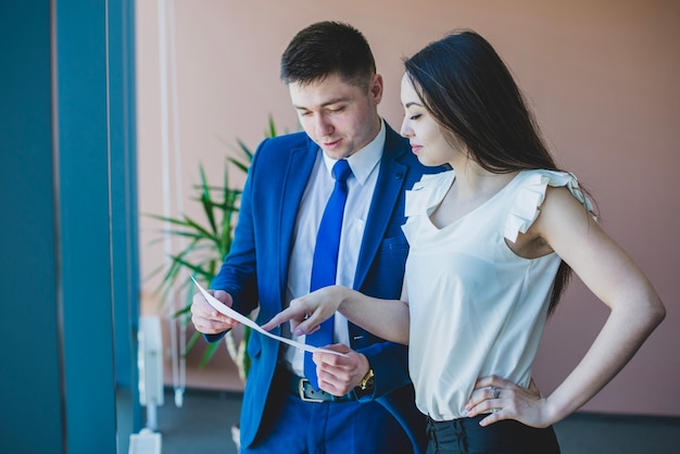 Zakenman en vrouw die een document controleert