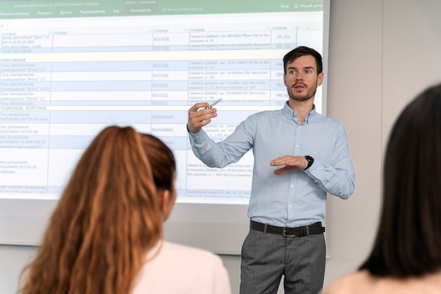 Gratis foto zakenman houdt een presentatie op kantoor voor haar collega's