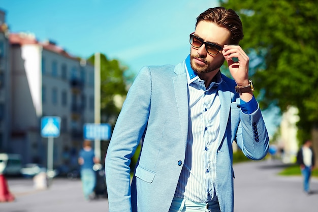 Gratis foto zakenman in blauw pak dragen van een zonnebril in de straat