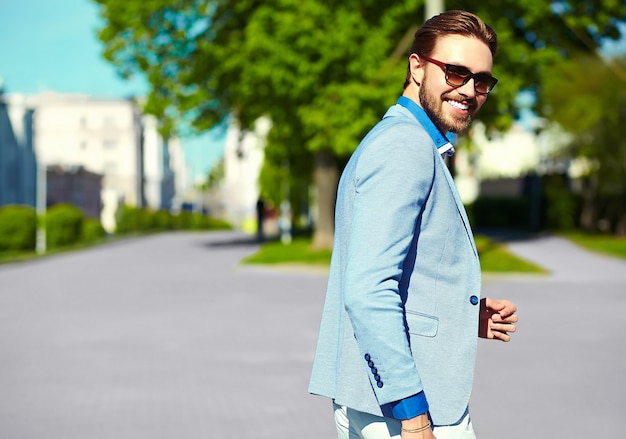 Zakenman in blauw pak dragen van een zonnebril in de straat