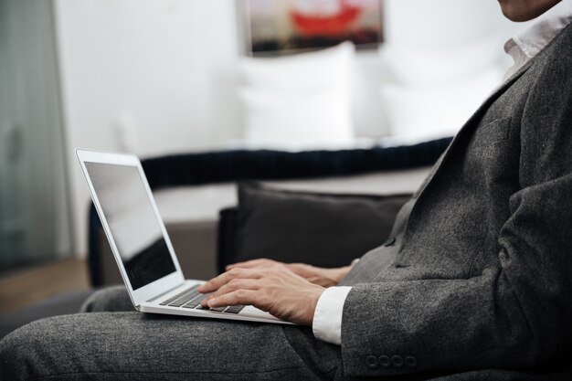 Zakenman in pak met een laptop op zijn schoot