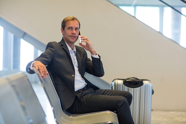 Gratis foto zakenman praten op mobiele telefoon in wachtruimte