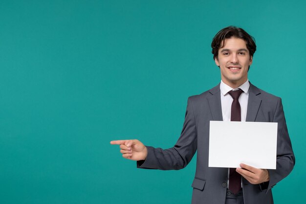 Zakenman schattige knappe jongen in grijs kantoorpak en stropdas blij met vel papier