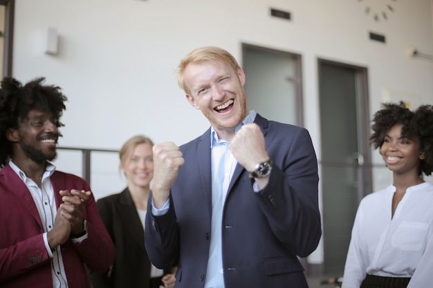 Zakenman viert zijn succes na het presenteren van projectvoorstel aan zijn multi-etnische partners