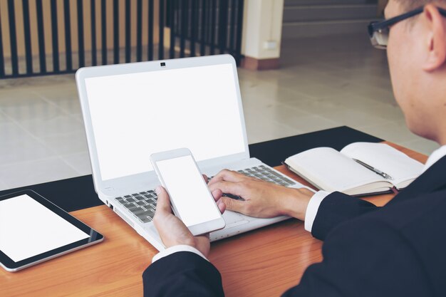 Zakenman werken op laptop en slimme telefoon.