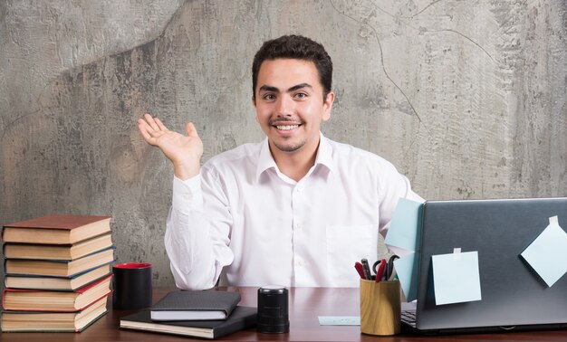 Zakenman zittend aan het bureau terwijl lachend.