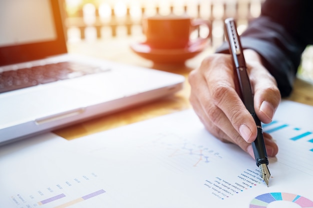 Gratis foto zakenmensen die financiële charts bespreken - close-up shot van handen over tafel