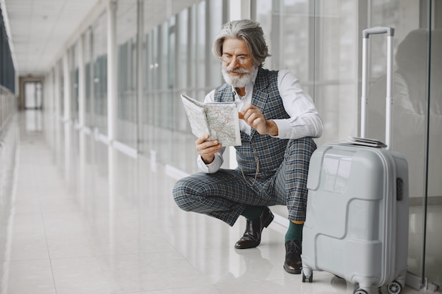 Zakenreis. Corporate en mensen concept. Man in een grijze vacht. Oudste met een kaart.