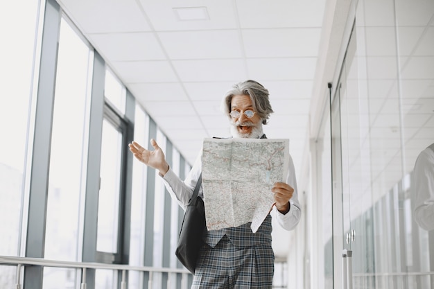 Zakenreis. Corporate en mensen concept. Man in een grijze vacht. Oudste met een kaart.