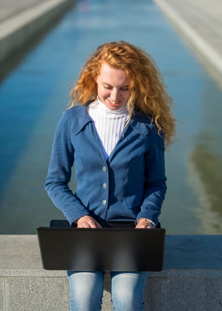 Zakenvrouw buitenshuis op haar laptop werkt