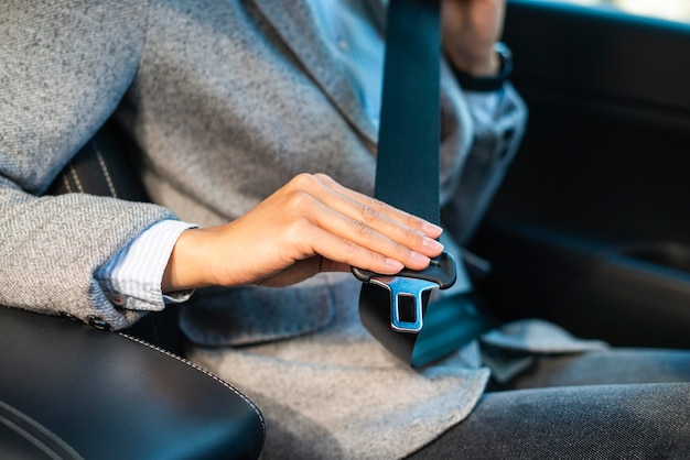 Zakenvrouw de veiligheidsgordel in de auto zetten