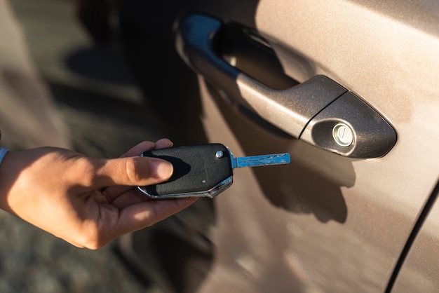 Zakenvrouw die de sleutel gebruikt om haar autodeur te openen