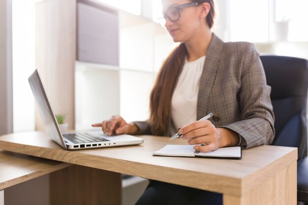 Zakenvrouw die op laptop werkt vanuit haar kantoor