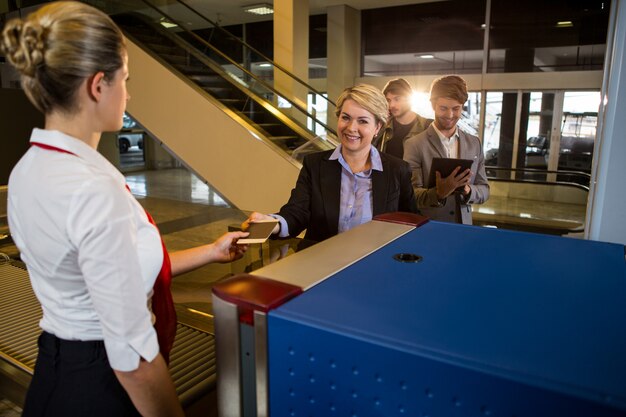 Zakenvrouw in de rij die paspoort en instapkaart ontvangt