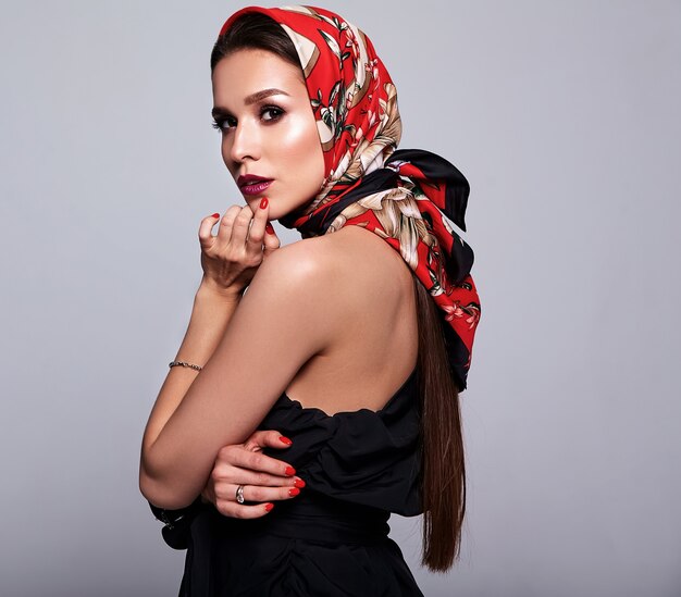 zakenvrouw in zwarte jurk met avond make-up en kleurrijke lippen in rode sjaal